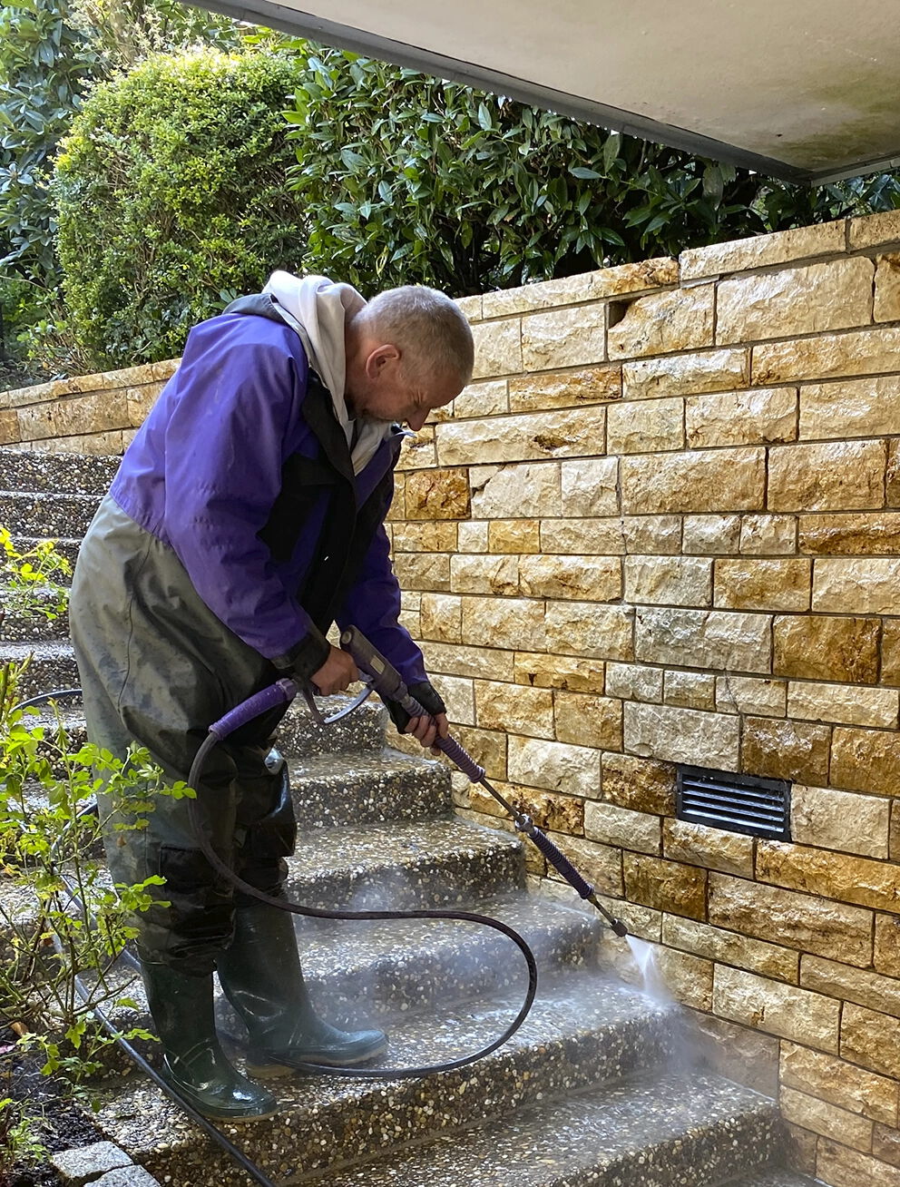 Detailaufnahme einer Treppenreinigung im Außenbereich: Reinigung von Trittstufen zur Wiederherstellung der Rutschhemmung.