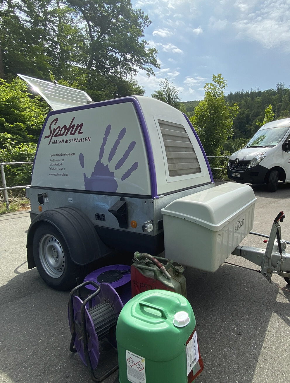 Mobile Reinigungsanlage von Spohn Malen & Strahlen mit Wassertank, Schläuchen und Reinigungsmitteln für professionelle Außenreinigung.