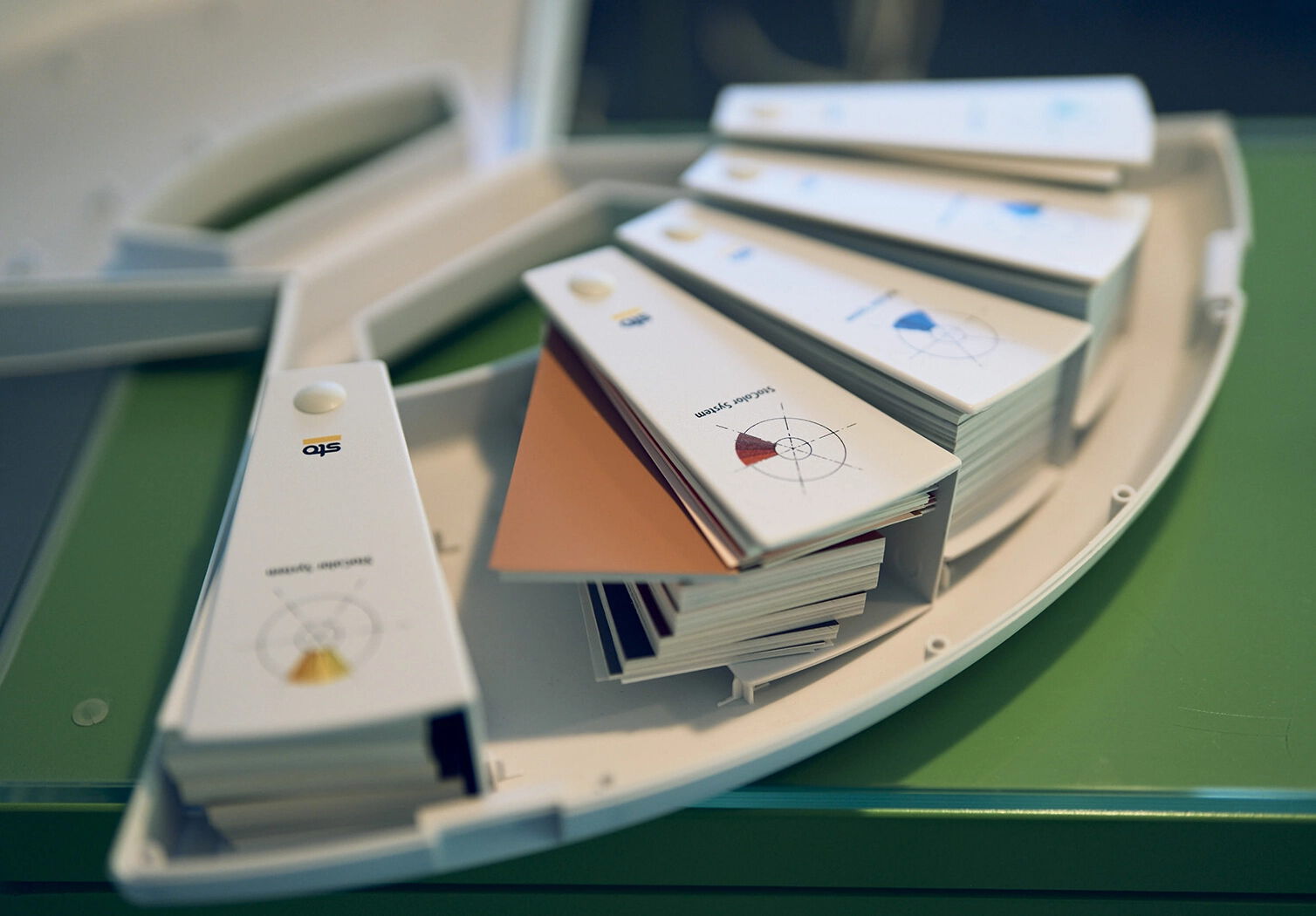 Detailaufnahme eines Farbmusterrings mit verschiedenen Fassadenfarbtönen, aufgefächert zur professionellen Farbberatung.