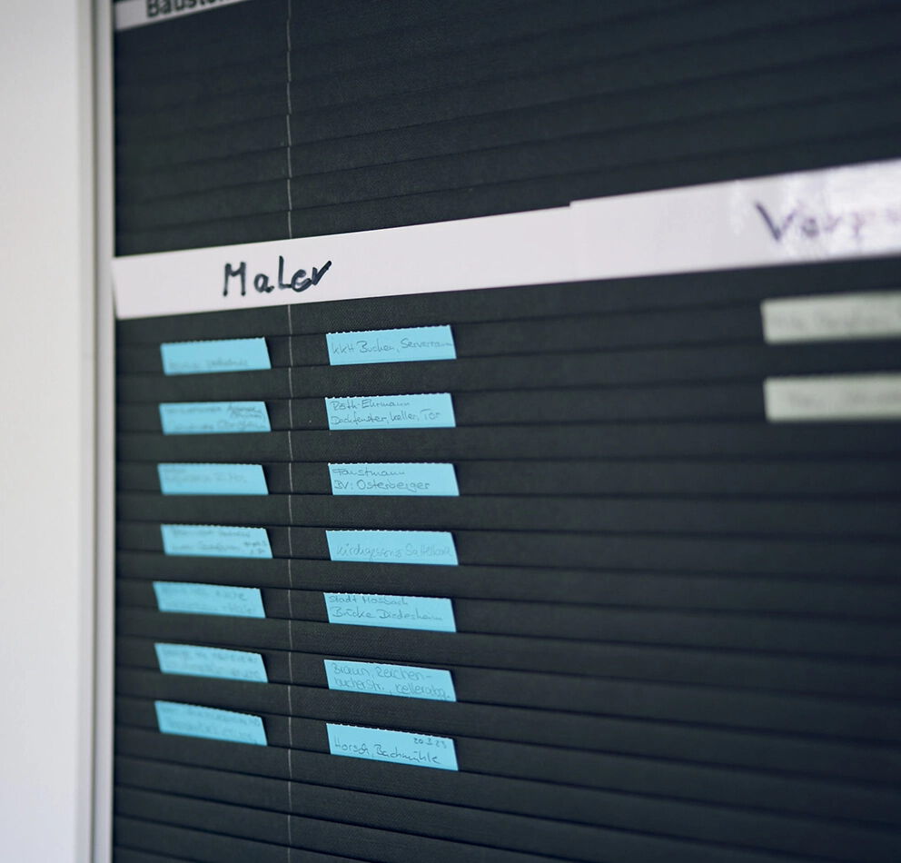 Detailaufnahme eines internen Einsatz- und Terminplans für Malerarbeiten mit beschrifteten Markierungen und Projektnotizen.